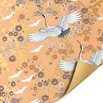 Cadeaupapier met kraanvogels en bloemen op een perzikkleurige achtergrond – oosters geïnspireerd en verfijnd